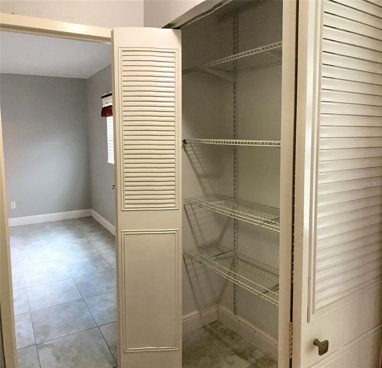 Hallway closet is spacious, includes adjustable shelving system.