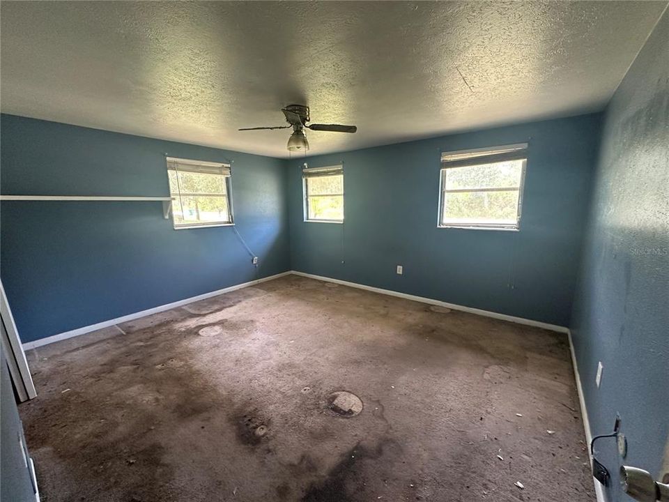 Primary bedroom.  I think it is terrazzo flooring under this carpet.