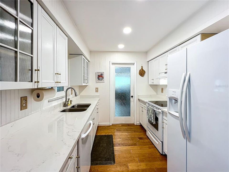 Glass door leads to the large inside laundry and utility room from the kitchen