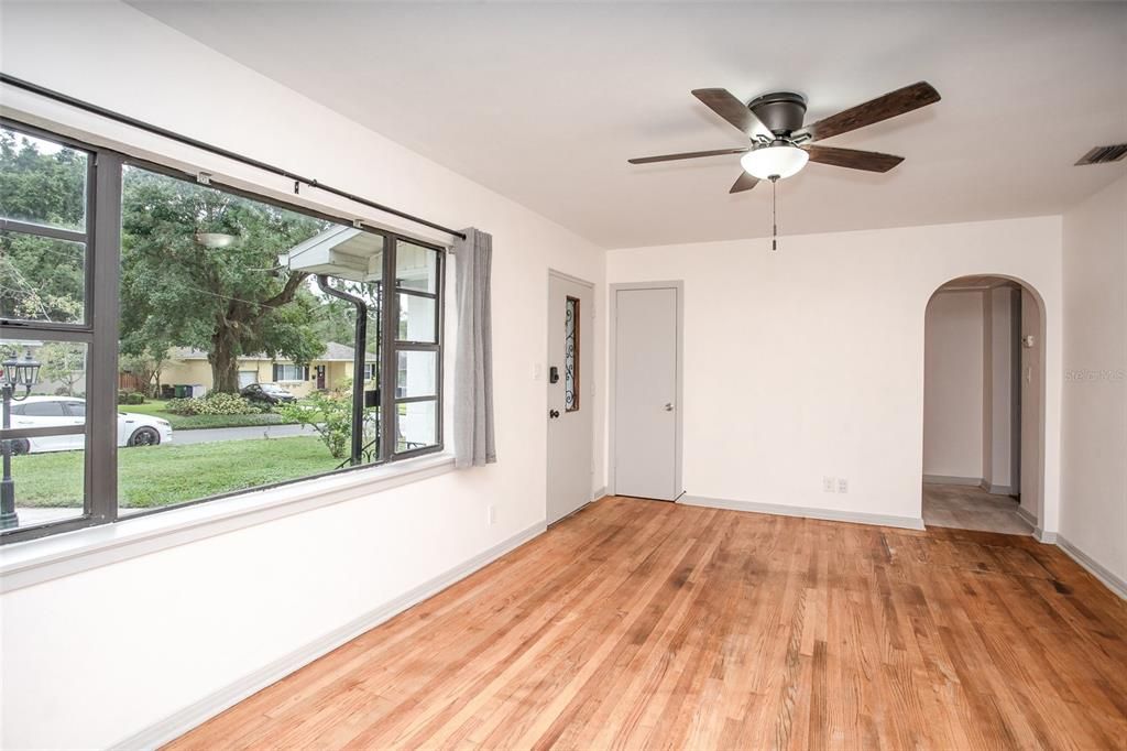 The living room features an oakwood floor, a picture window and arched doorways.