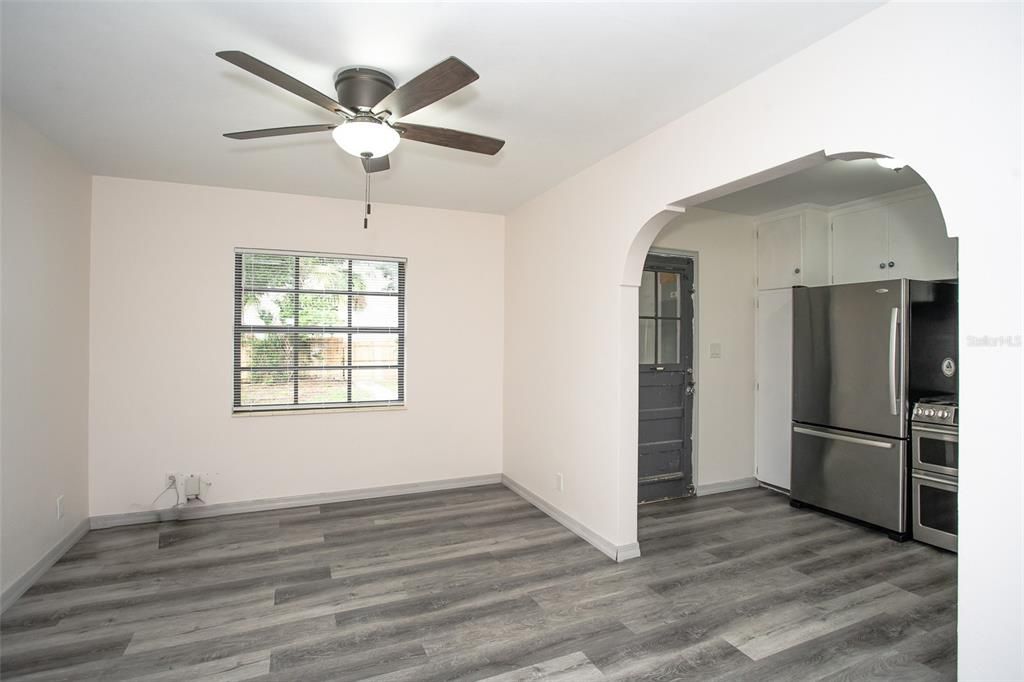 The kitchen features vinyl flooring, a window for natural light and an arched doorway.