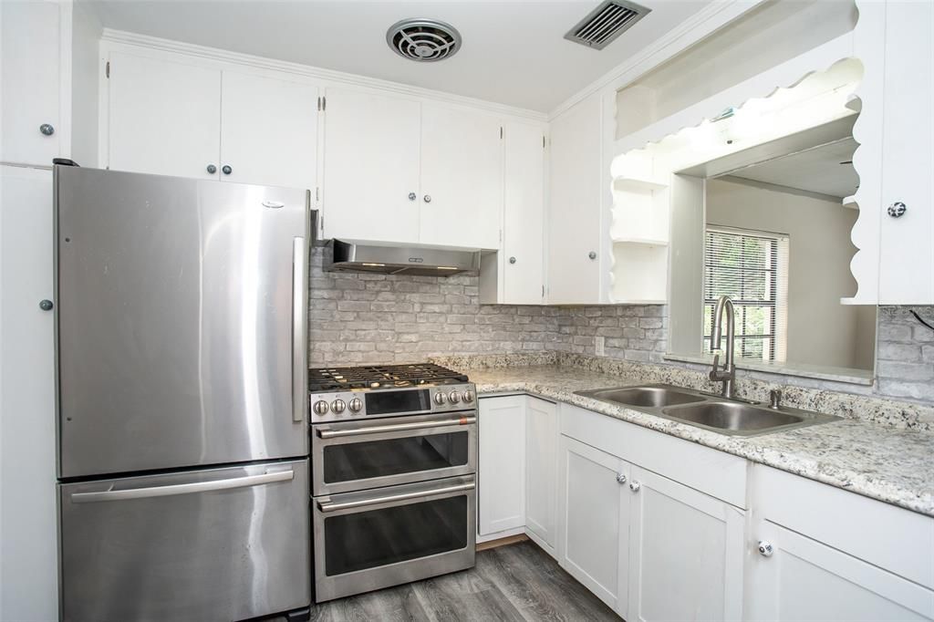 The kitchen features wood cabinets, family size stainless steel refrigerator-freezer, a double stainless steel sink with a stainless steel faucet with pulldown sprayer.