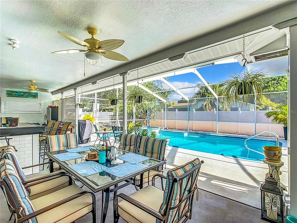 The patio has a large covered area complete with table, chairs, bar and bar stools which stay with the property. The ceiling fan is new.