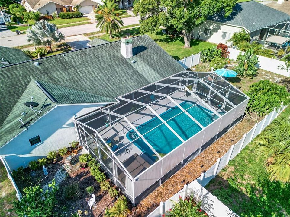 Overhead view of pool area. To the left is another fenced in area that has plants and assorted statues.