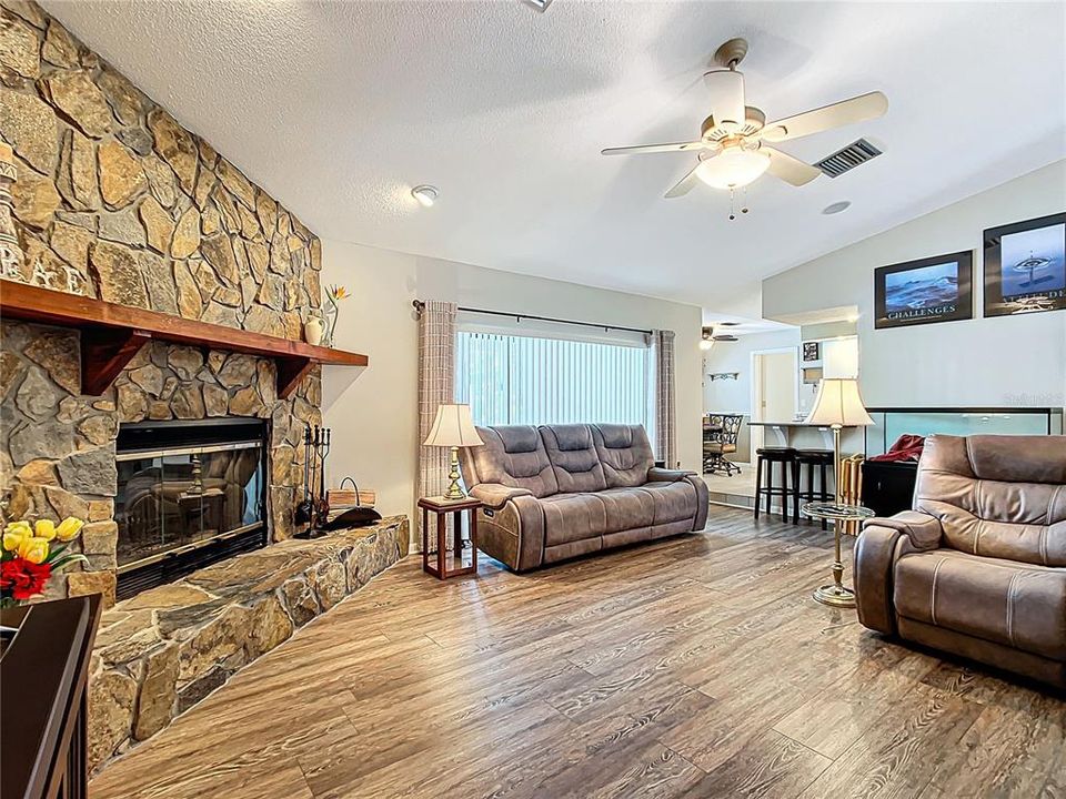 Living room has fantastic size. A stone faced wood burning fireplace gives a rich look to the room. There is a sliding door behind the couch which opens out to the pool and party area.