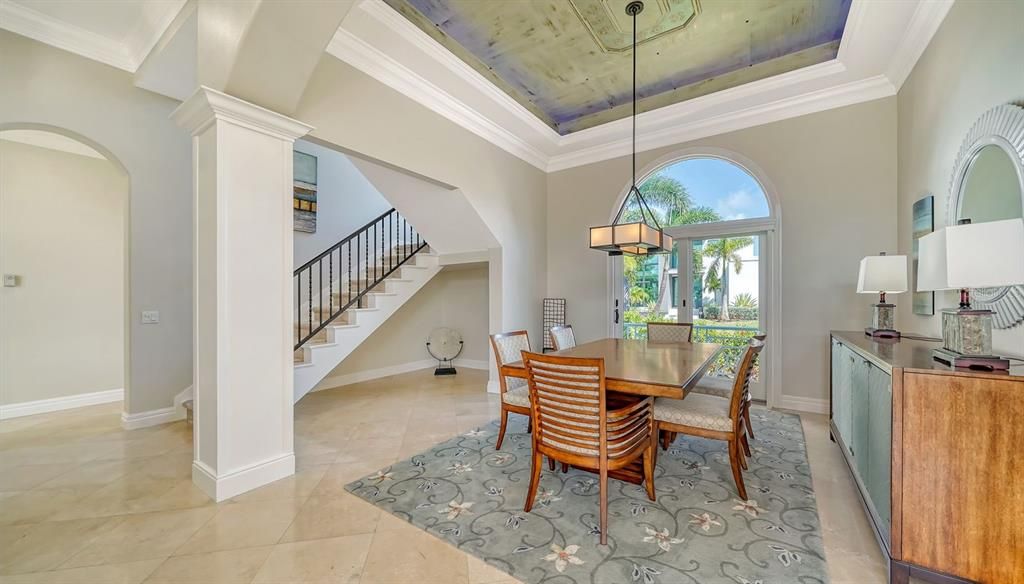 Formal dining room with tray ceiling and custom lighting