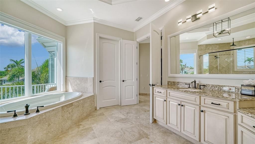 Separate water closet, garden tub, and double vanities make this impressive primary bathroom shine