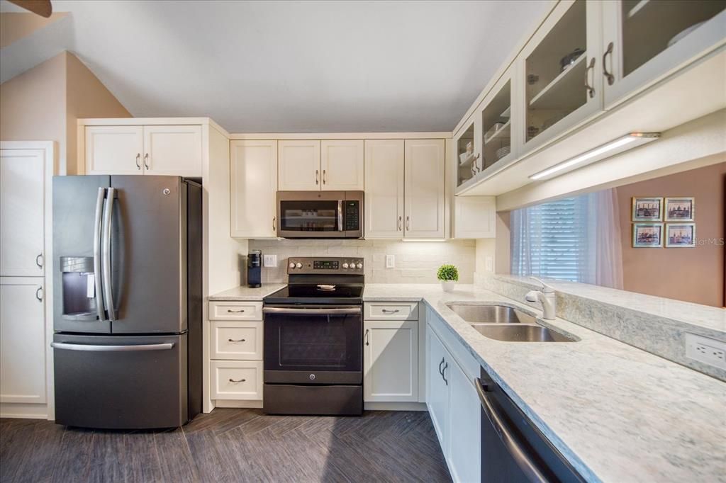 Kitchen renovation with cabinets, quartz counters, appliances & matched flooring~