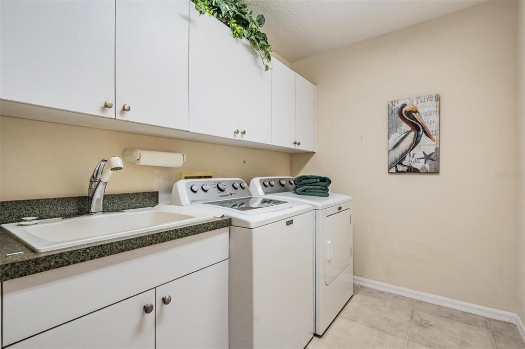 Walk-in laundry room with built-in storage and utility sink