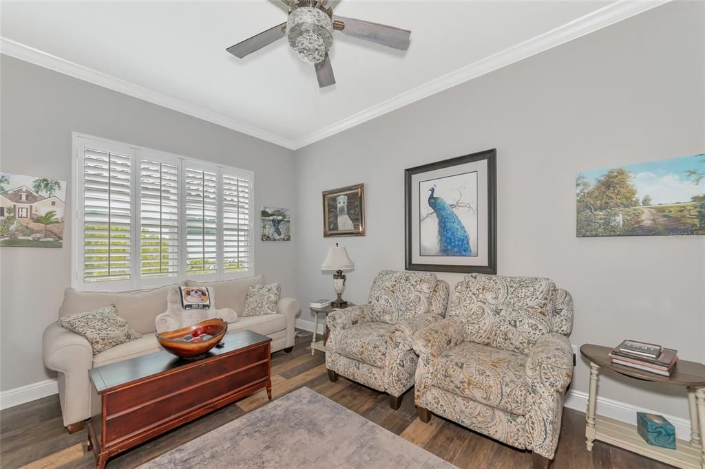 den with wood floors, and crown moldings, glass french door entrance.