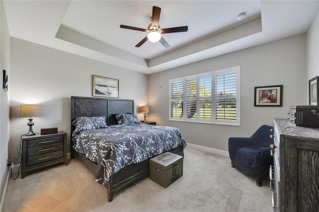 Large primary bedroom with tray ceilings