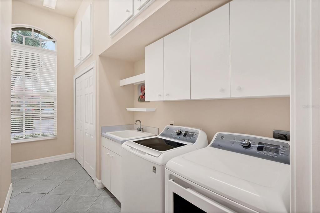 large laundry room with tons of extra storage space..cabinets up above provide lots of storage space