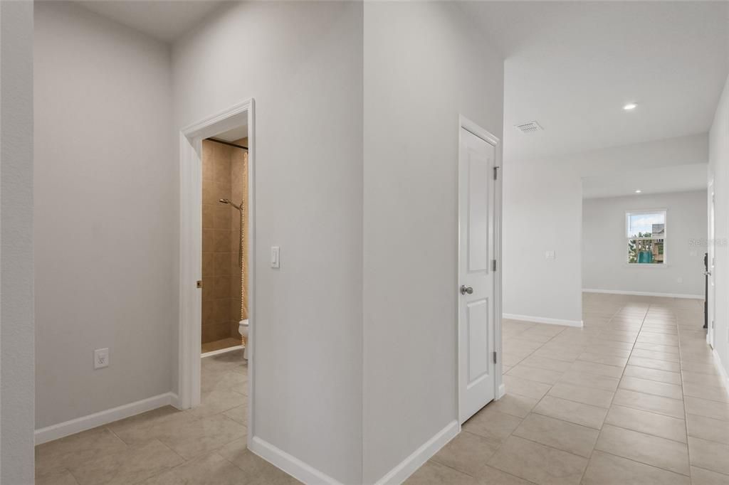 View from the Foyer looking down the hallway to the dining room on your right and the spacious family room and kitchen space! The front of this photo shows the full bath with an office or bedroom just across the hall.