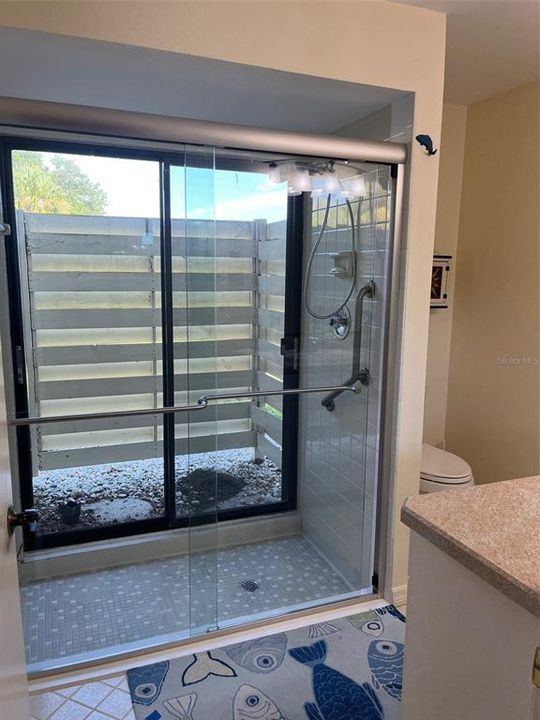 Primary bedroom bathroom with new doors to the walk-in shower. Exterior sliders allow humid air to escape into the privacy garden.