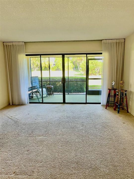 Spacious living room with wide view of the screened lanai and back yard.