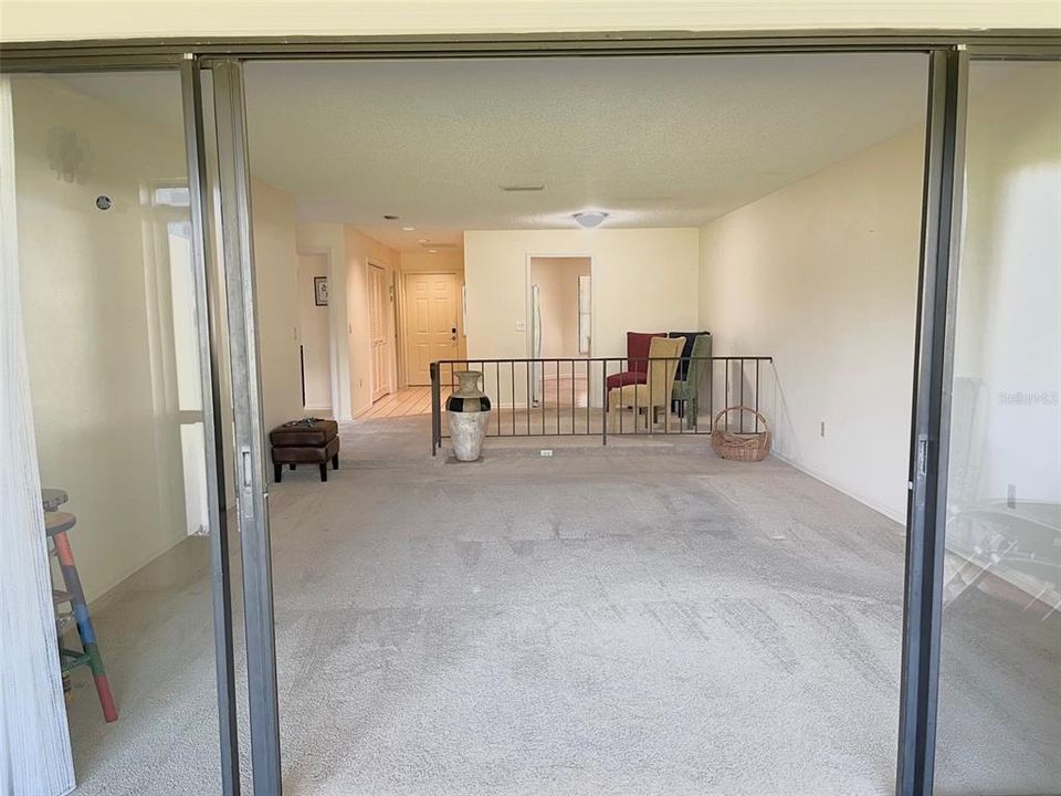 View from the lanai through the  living room into the dining room, foyer, and kitchen