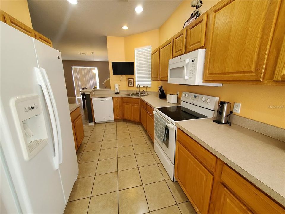 Plenty of counter space and cabinets in the kitchen. Microwave over range, Title floors and recessed lighting.