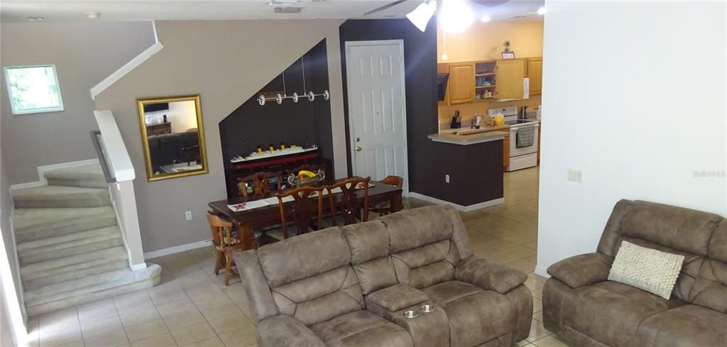 View of the dining area and staircase leading to the second floor.  The sliding back door is for the back.