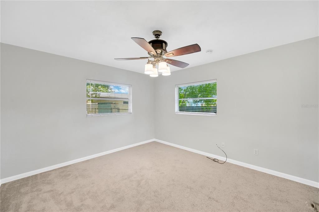 Primary Bedroom is 13'x 12' and looks out to the backyard and has recently installed carpet and ceiling fan.