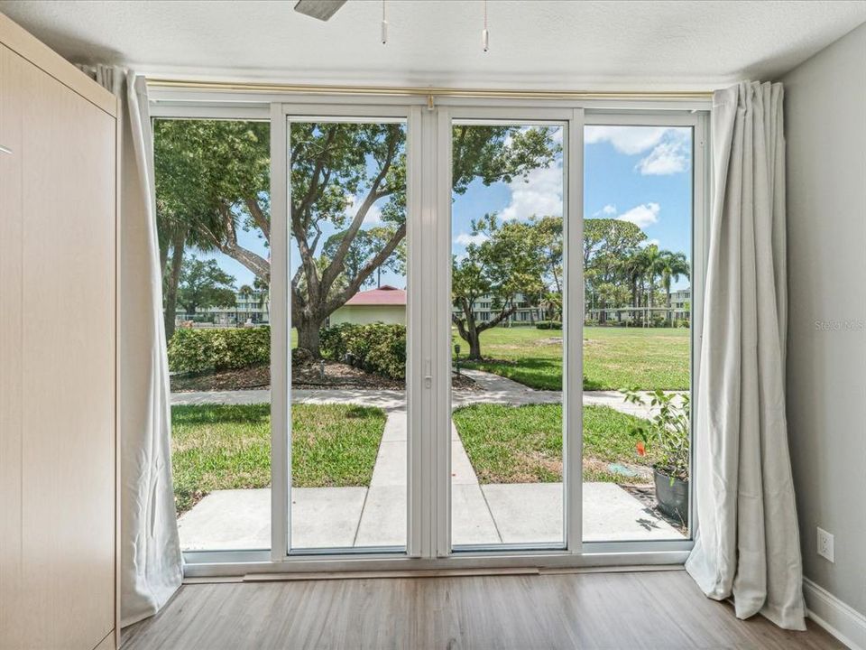 Bonus room with wall-to-wall newer sliding glass doors providing lots of light and peaceful view of the courtyard and lush landscape.