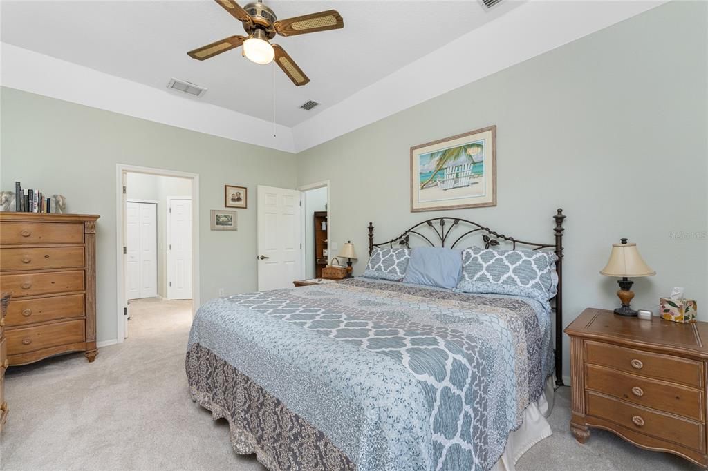 Additional features in the Master Bedroom include carpeted flooring, tray ceiling with a fan, and a large walk-in closet.