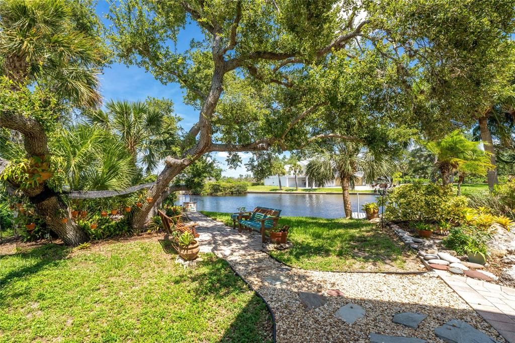 The brick pavers lead to a stone pathway down to water-view.