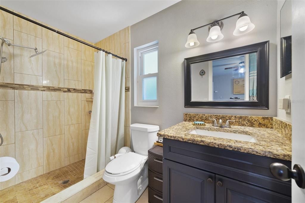 Granite counters continue into the bathroom where you will also find a walk-in shower with custom tile surround.