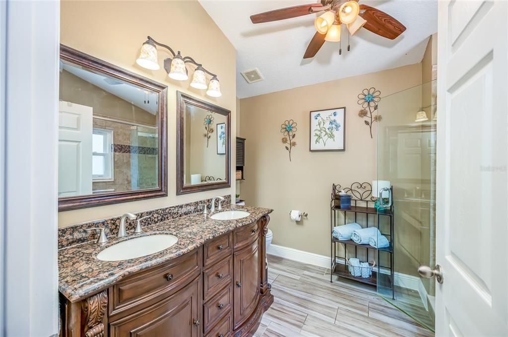 updated bathroom with double sinks and fan