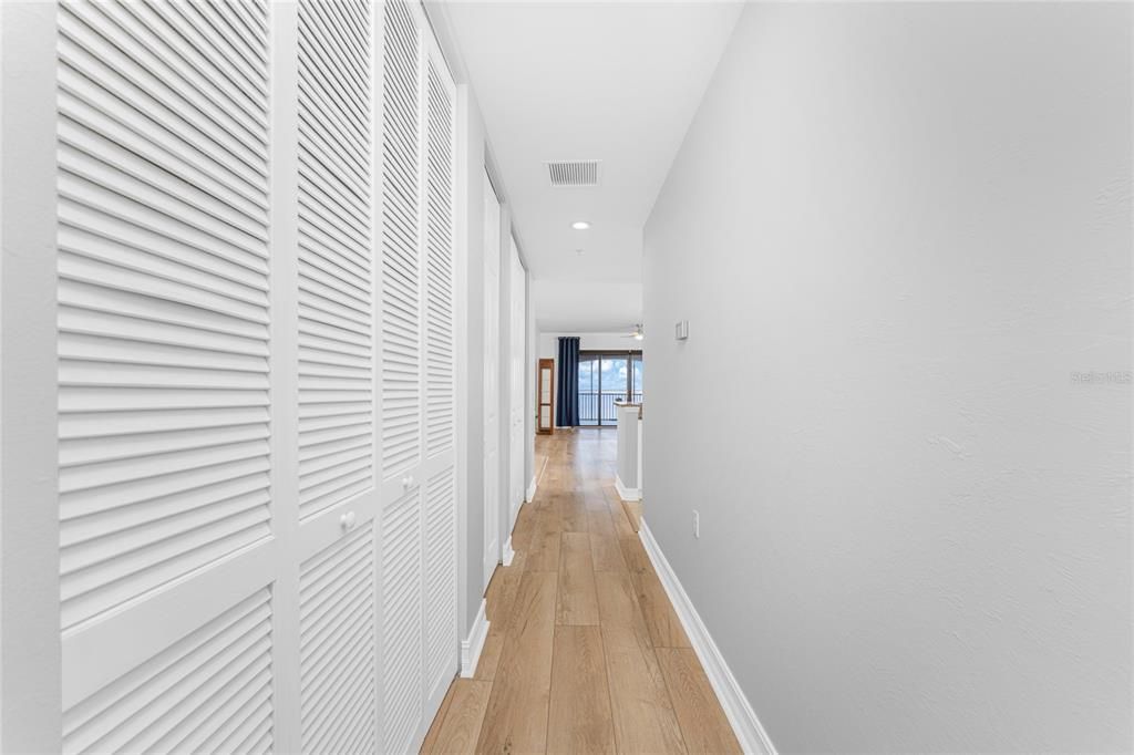 Hallway from guest end of home is lined with closets