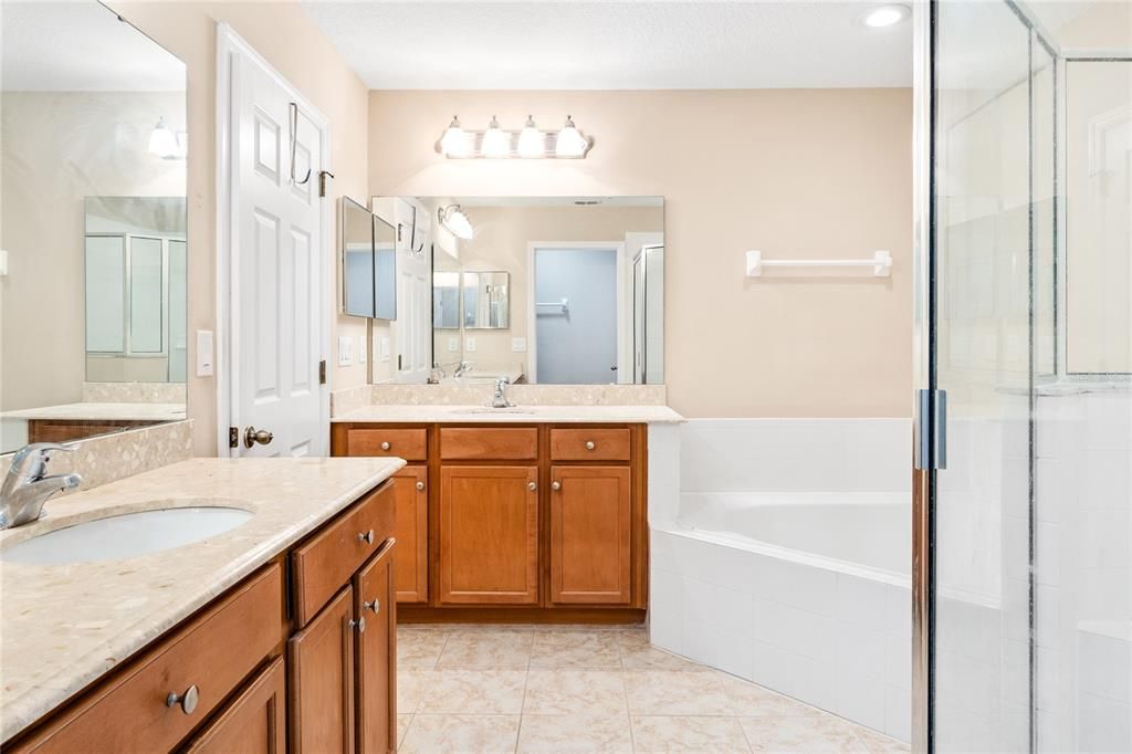 Main bathroom with granite countertops, garden tub, shower with bench and tiled floors