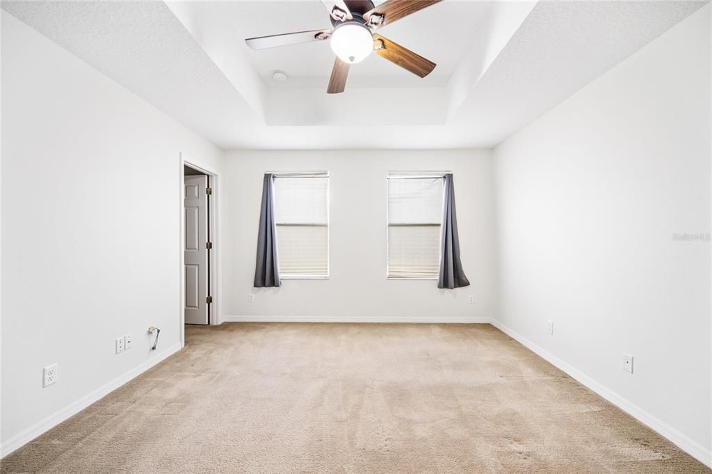 Primary bedroom with tray ceiling and the door on the left leads to the huge closet