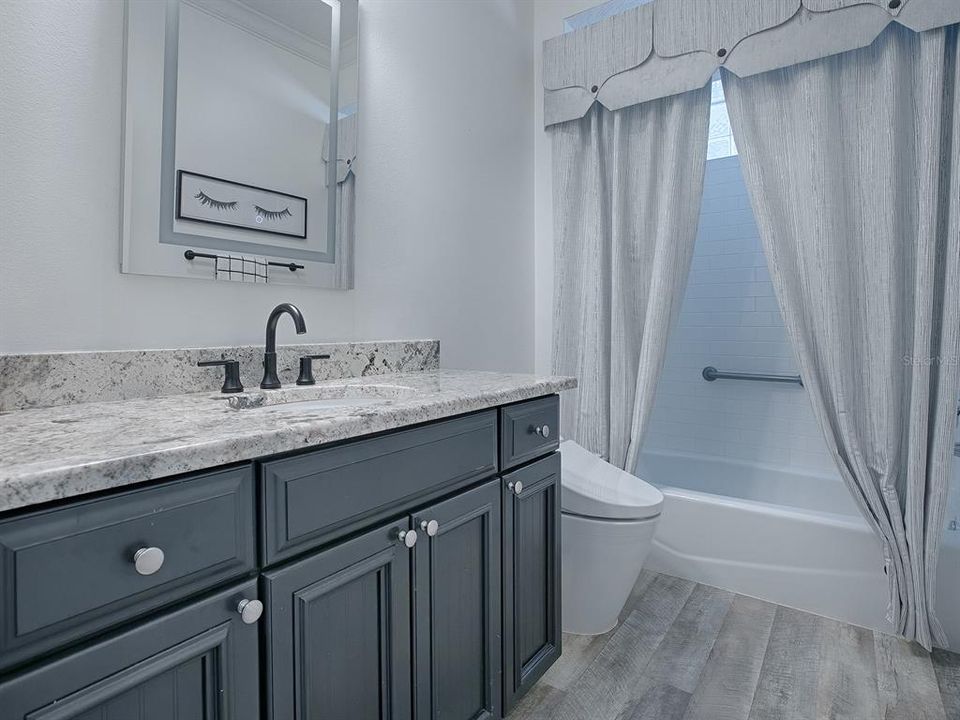 GUEST BATH WITH NEW GRANITE COUNTERTOPS, LIGHTED VANITY MIRROR WITH ADJUSTABLE SETTING, ONE PIECE "SMART" NEW AUTOMATIC TOILET.  CUSTOM SHOWER CURTAIN.