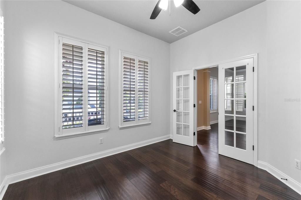 A sleek Dining room with plantation shutters.