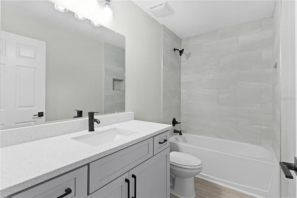 Guest bath with large vanity and tiled tub surround