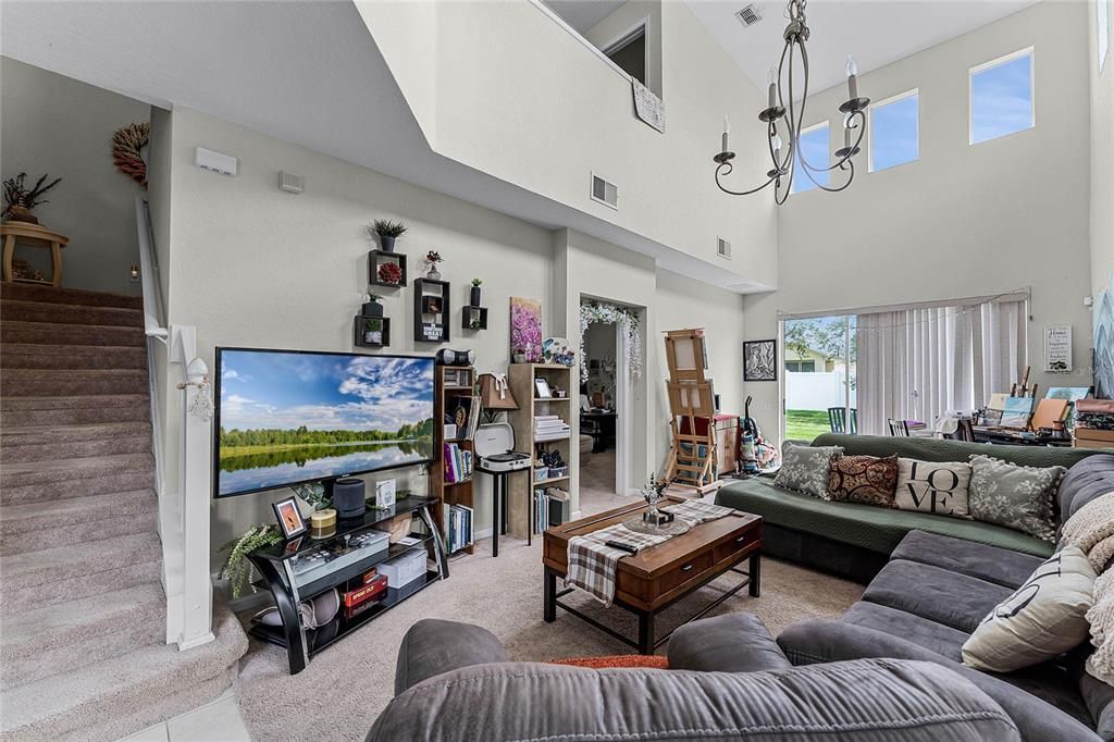 Step inside and be captivated by the airy living room/dining room combo, featuring soaring cathedral ceilings that amplify the natural light pouring in.