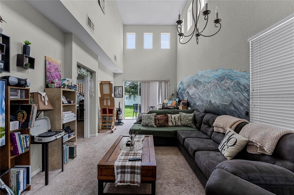 Step inside and be captivated by the airy living room/dining room combo, featuring soaring cathedral ceilings that amplify the natural light pouring in.