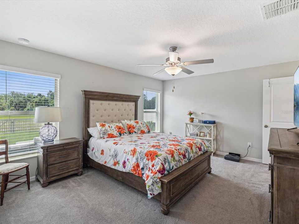 View of the ample sized master suite with beautiful views of backyard conservation area out of the windows