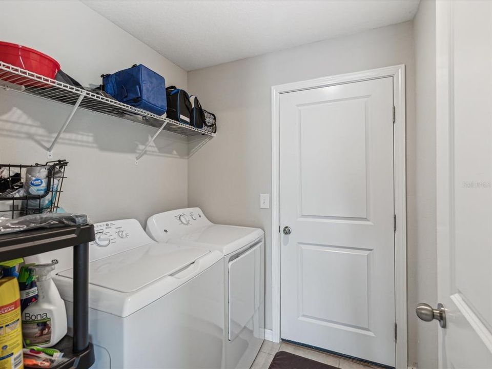 Nice sized laundry room with washer and dryer and storage space with the door that leads into the 2 car garage