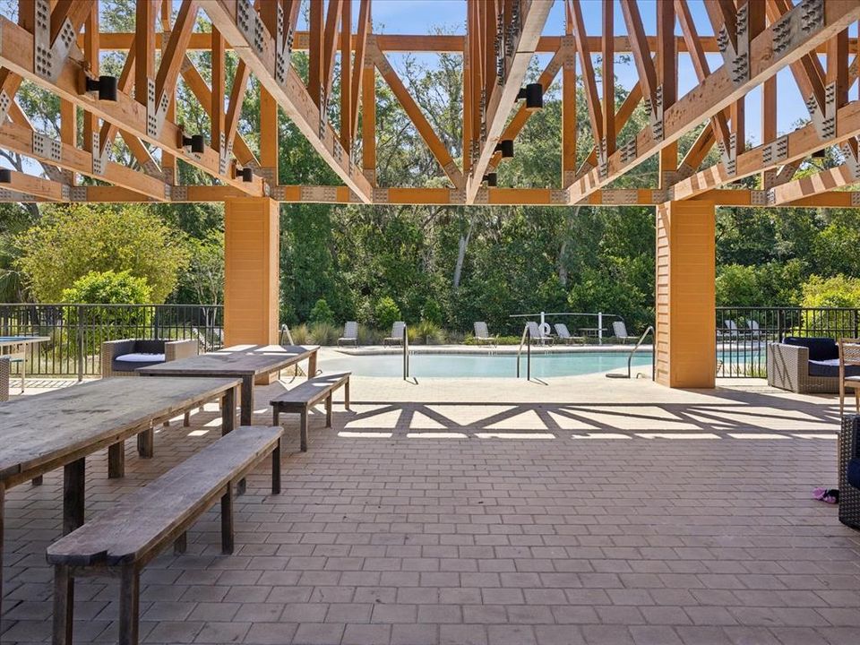 View of the under roof pavilion area at the community pool just a very short walk away from the home