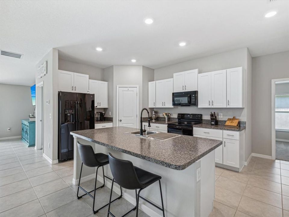 View of the kitchen with the family room in the background showing the open concept floorplan