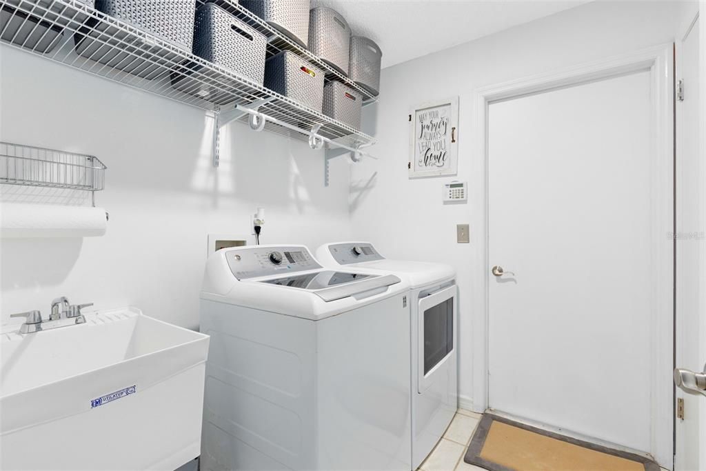 Super duper laundry room with storage and utility sink.