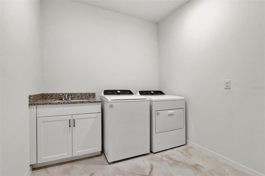 Laundry room with Whirlpool washer and gas dryer, laundry room sink and soft-close cabinets