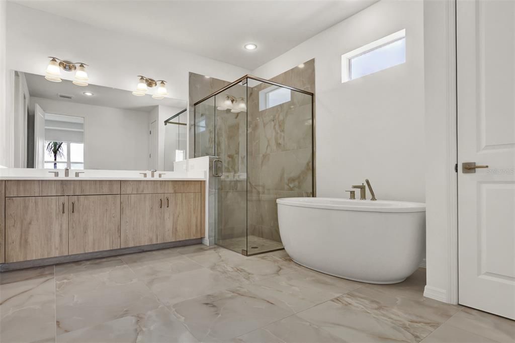 Luxe primary bathroom with free-standing Kohler soaking tub and luxe walk-in shower