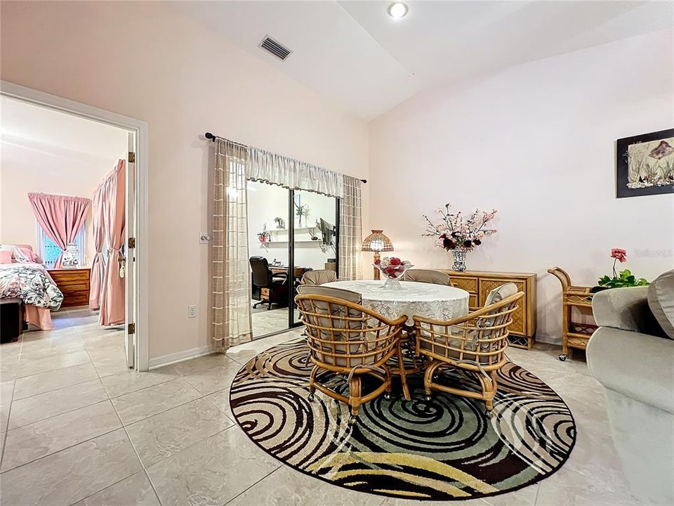 View of the primary bedroom, dinette area, and enclosed den/Florida room.