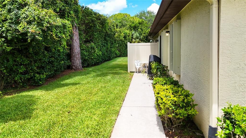 Back yard view with concrete patio for a grill.