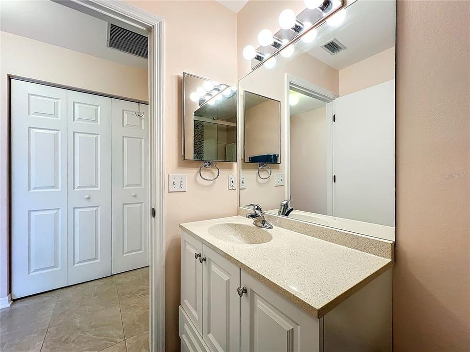 Guest bathroom sink with solid surface counter.