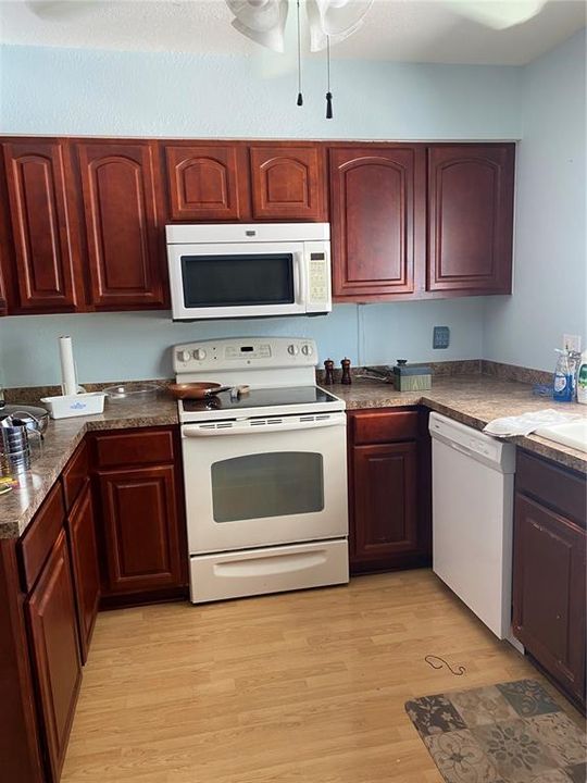 Kitchen with cherry cabinets.  There is no refrigerator.  Other appliances work.