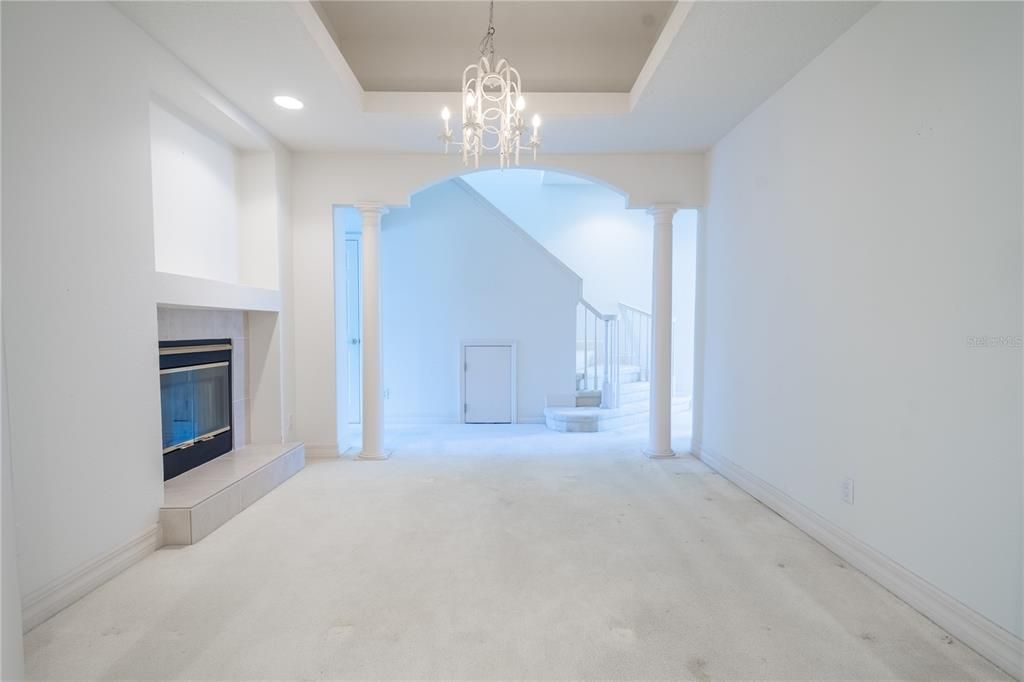 The formal dining room features a arched entryway with columns.