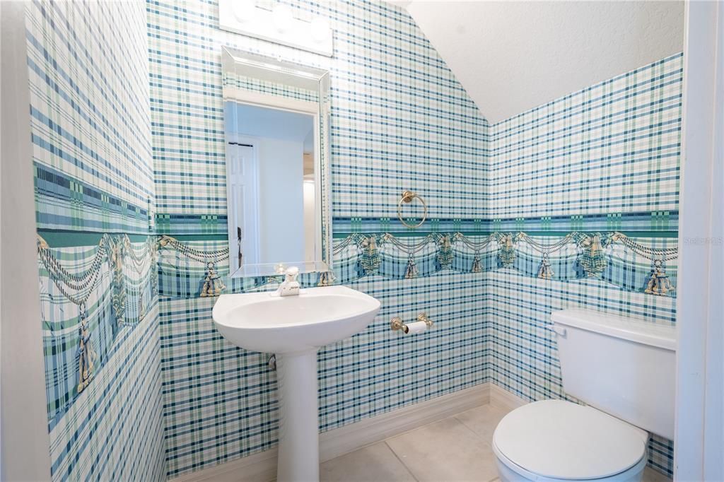 A half bath is conveniently located on the first level has a ceramic tile floor, and features a mirrored pedestal sink and commode.
