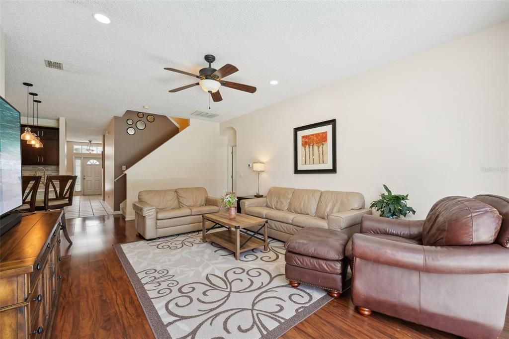 THE MAIN FAMILY ROOM that OVERLOOKS THE BEAUTIFUL POOL through OVERSIZED SLIDERS & is also complimented by NEWER LAMINATE FLOORING, HIGH CEILINGS, FRESH PAINT & NEW FIXTURES.